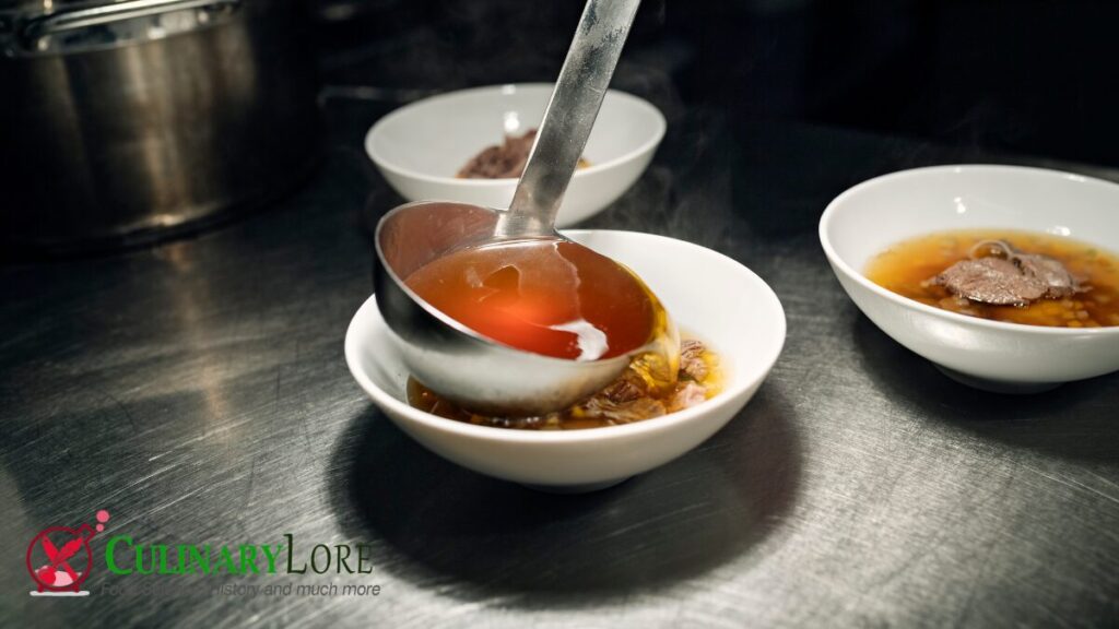 ladling consomme into a bowl of carrots and venison