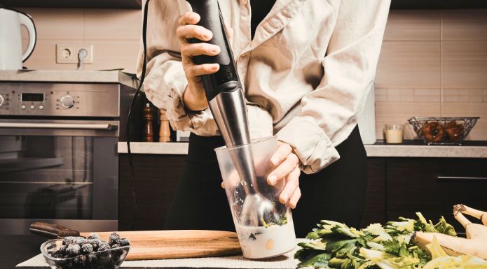 woman using immersion blender 