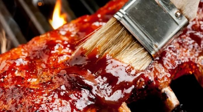 putting sauce on barbecue ribs