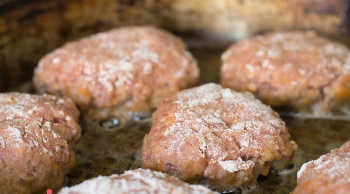burgers cooking in overcrowded pan