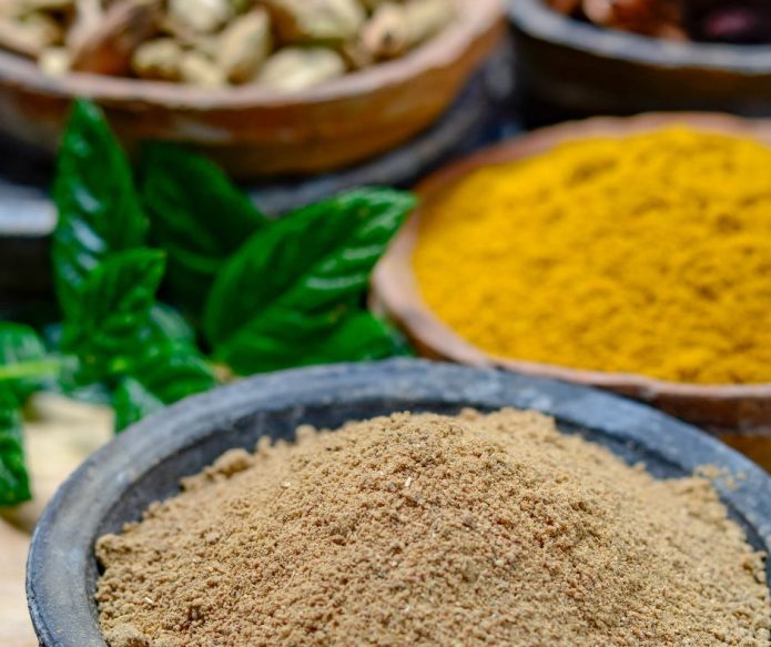 amchur powder with curry powder in background