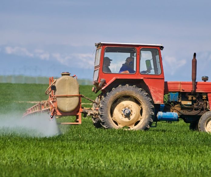 farmer applying pesticide to crops
