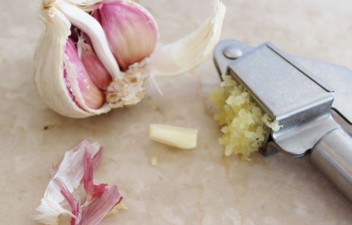 garlic press with garlic