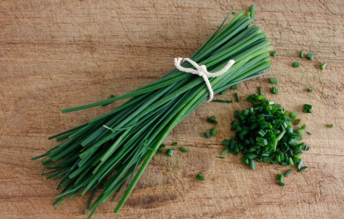 chives whole and chopped on a cutting board