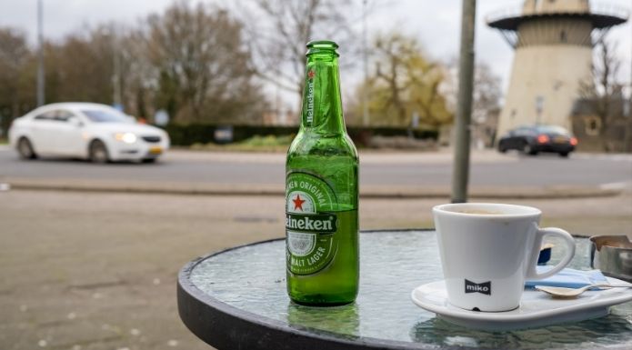A fresh bottle of Heineken sitting on a Dutch café patio table.