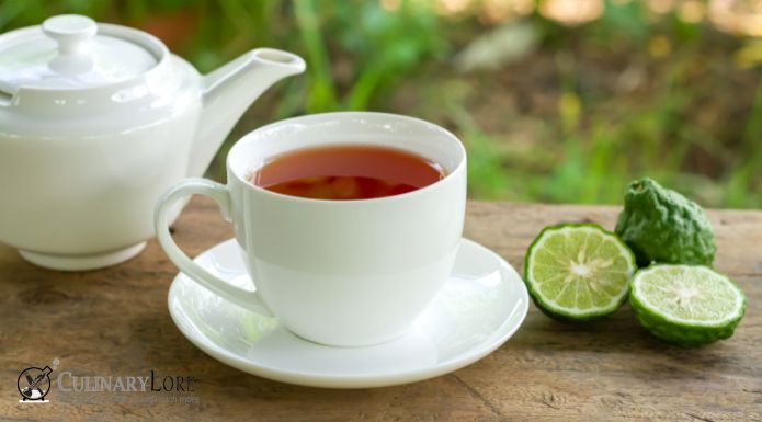 Earl Grey tea in white cut with fresh bergamot fruit and sliced in background. 